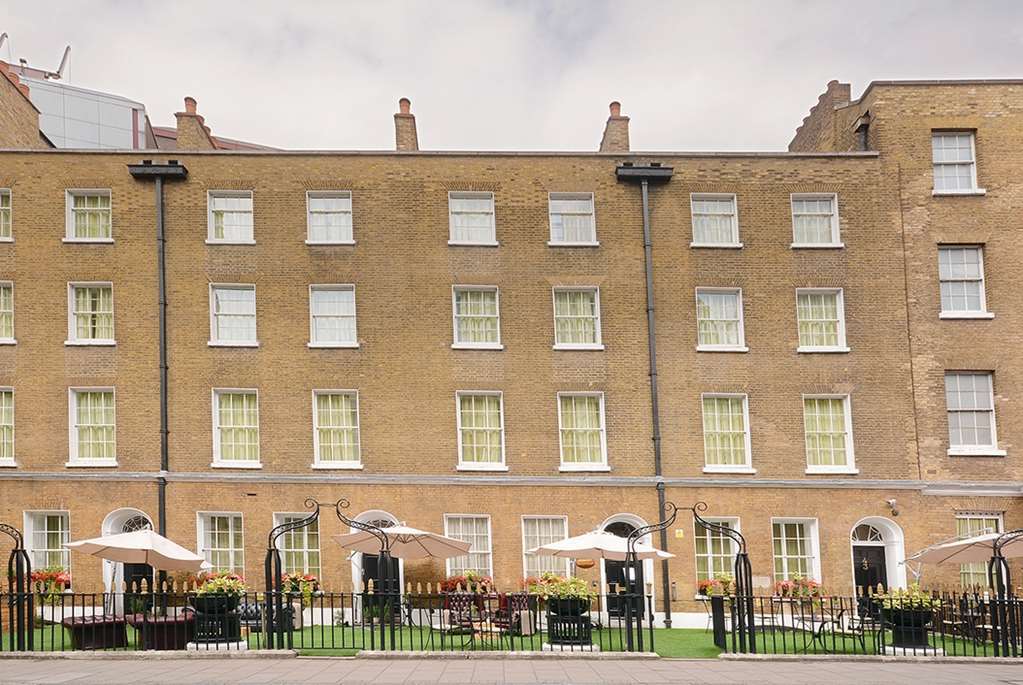 Montcalm Brewery Townhouse Hotell London Exteriör bild The photo shows a brick building with several windows on its facade. The structure appears to be three stories tall, featuring a symmetrical design with multiple windows that have white frames. In front of the building, there is a landscaped area wit