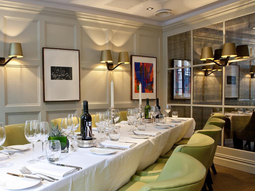 Montcalm Brewery Townhouse Hotell London Exteriör bild The photo shows an elegant restaurant setting with a long dining table that is neatly set for a meal. The table is adorned with a white tablecloth, glassware, and silverware, indicating that it is prepared for a special gathering or event. 

Behind t