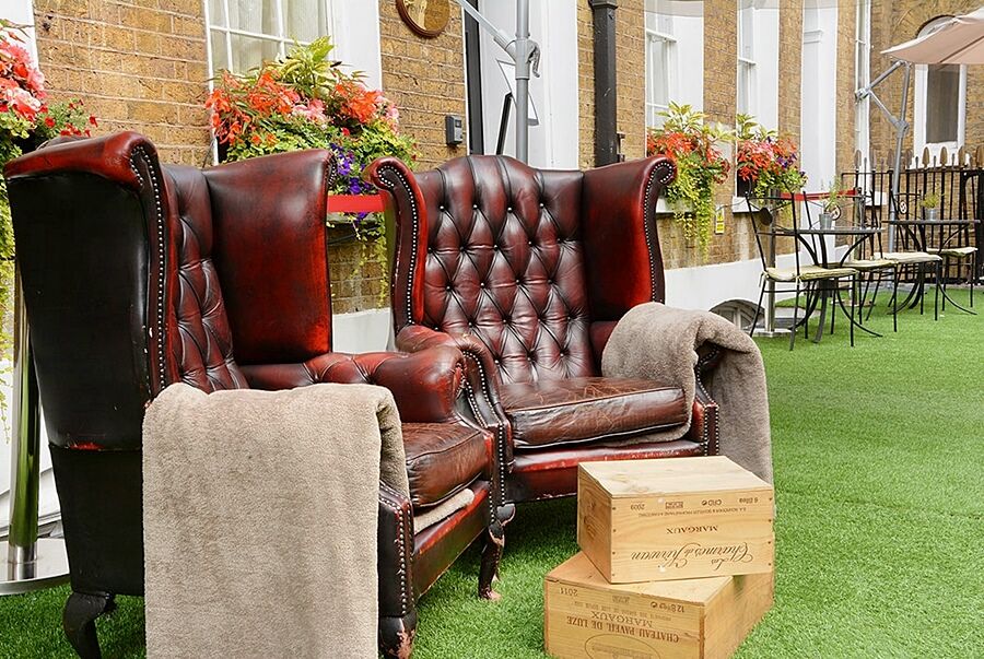 Montcalm Brewery Townhouse Hotell London Exteriör bild The photo depicts two large, elegant armchairs with a classic design, featuring rich burgundy leather upholstery and button tufting. They are positioned in a cozy outdoor setting, with lush green artificial grass beneath them. Next to the chairs, the